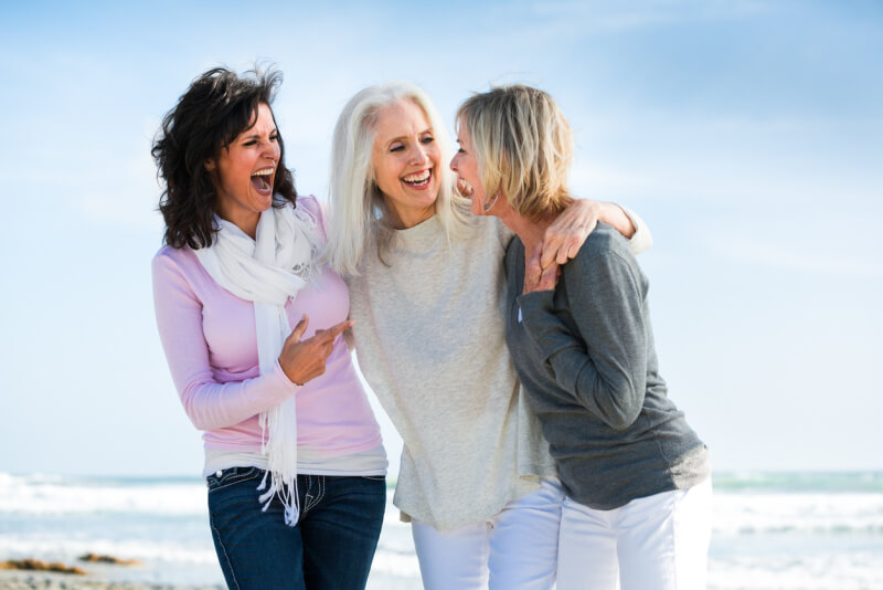 Portrait of three mature women having fun together at beach