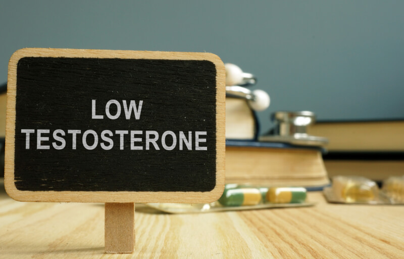 Sign low testosterone and book on wooden surface